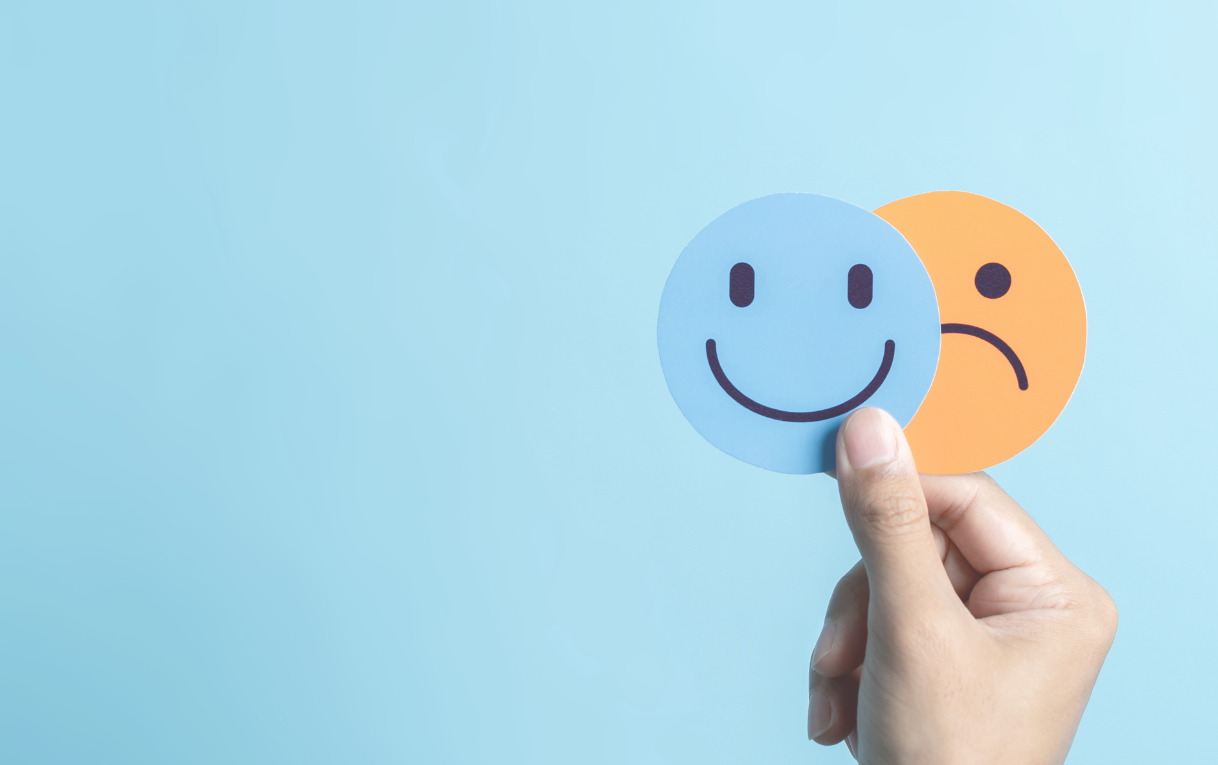 Smiley face and sad face on blue background