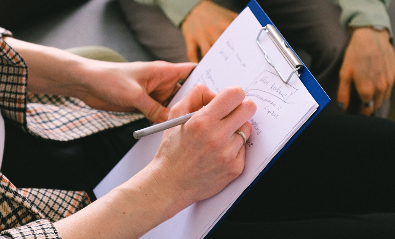 SGT Informed Consent - Person writing on clipboard